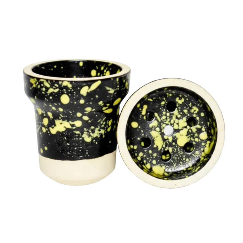 Cazoleta Elemento Fuego 2.0 Black Yellow fabricada en barro blanco poroso con esmalte de doble capa color negro y motas amarillas, azules y rojas, tipo tradicional con 7 agujeros y carga 15-17 gr en The Good Shisha