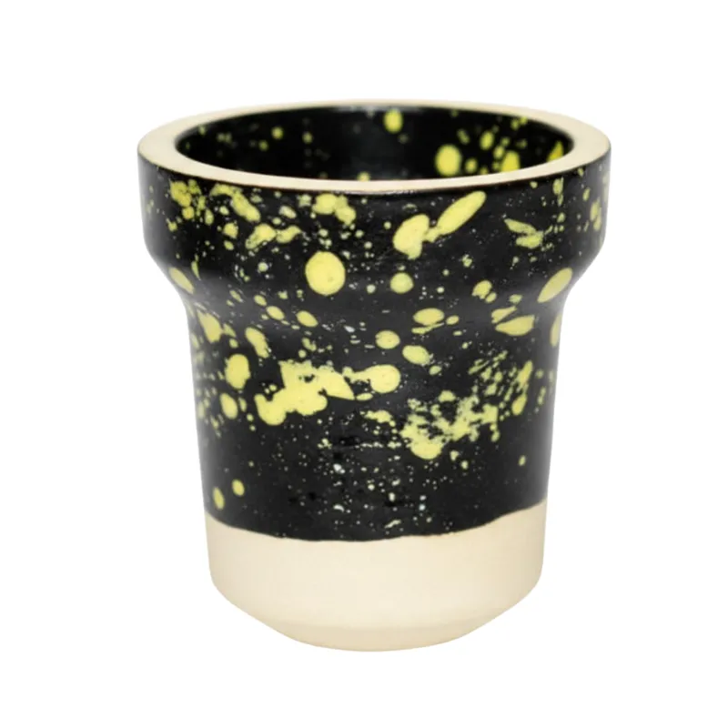Cazoleta Elemento Fuego 2.0 Black Yellow fabricada en barro blanco poroso con esmalte de doble capa color negro y motas amarillas, azules y rojas, tipo tradicional con 7 agujeros y carga 15-17 gr en The Good Shisha